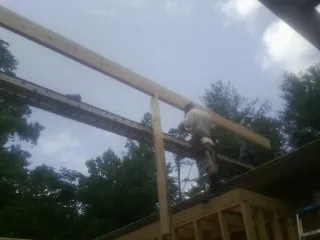 Carpenter setting a ridge beam over a new addition frame — Ice Dam Removal by Roofing Brothers in Airville