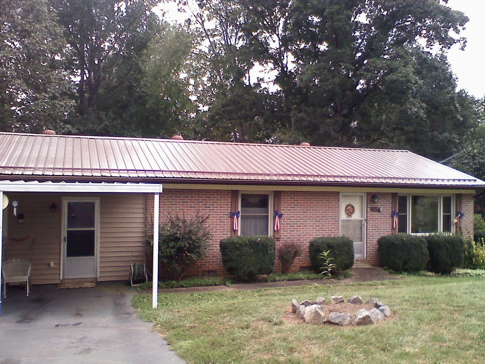 Bronze metal roof and carport on a brick ranch home — Roof Repair work by our crew in Airville